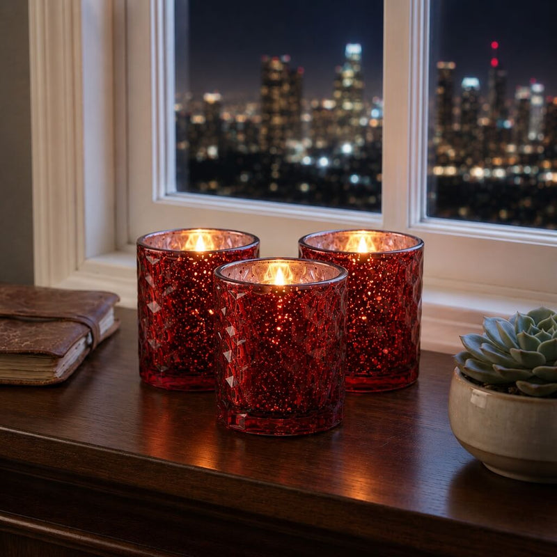 Red honeycomb votive candles glowing by window with city skyline at night - thumbnail number 7
