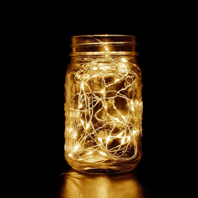 Mason jar filled with warm white fairy lights glowing in the dark.  - thumbnail number 1