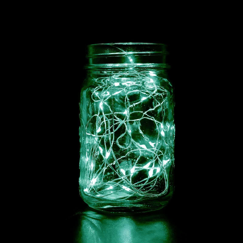 Mason jar filled with green fairy lights glowing in the dark.  - thumbnail number 1