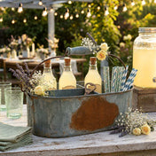 Weathered metal gray caddy holding drinks, straws, and flowers at a party - thumbnail number 3