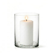A lit white pillar candle burning cleanly inside a clear glass Wide Cylinder Vase - thumbnail number 3