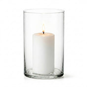 A lit white pillar candle inside a clear glass cylinder vase on a white background - thumbnail number 3
