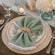 Place setting featuring a natural lata ring securing a green napkin on plates - thumbnail number 8