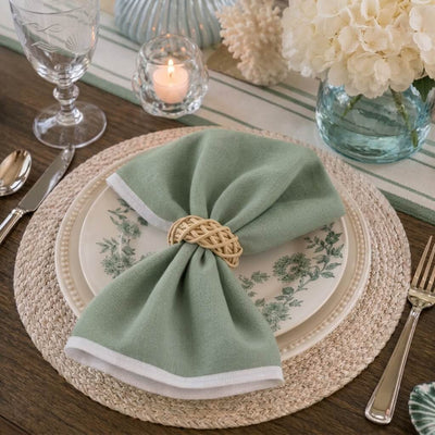 Place setting featuring a natural lata ring securing a green napkin on plates - thumbnail number 8