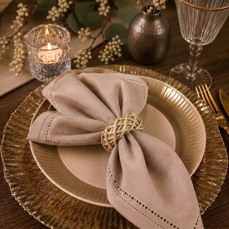 Close-up of a natural lata napkin ring securing a beige cloth napkin on a gold charger plate - thumbnail number 9
