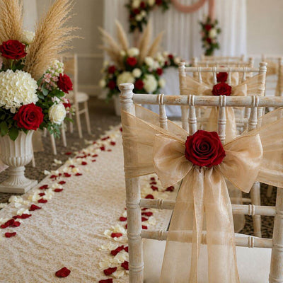 White chairs adorned with gold sashes and red preserved roses for a wedding aisle - thumbnail number 2