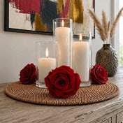 Burgundy red preserved roses surround three cylinder candles on a woven tray - thumbnail number 7