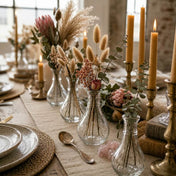 Small clear glass bud vases with dried floral arrangements on a rustic dining table - thumbnail number 5
