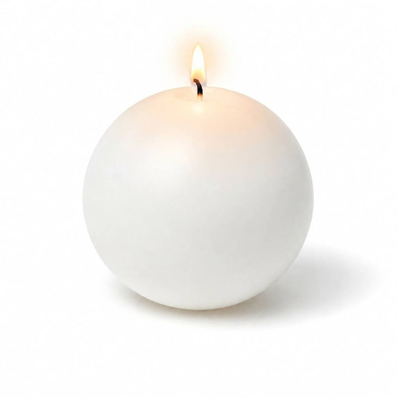 A lit white sphere candle casting a soft glow against a plain white studio backdrop - thumbnail number 2