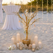 Gold faux manzanita tree centerpiece with white flowers and candles on a beach - thumbnail number 3