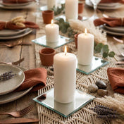 Lit candles on square mirrored coasters set on a rustic table runner - thumbnail number 3