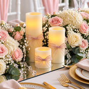 Ivory flameless LED pillar candles decorated with bows, surrounded by pink and white flowers - thumbnail number 4