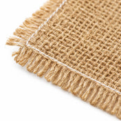 Close-up of a natural burlap wrap square with white stitched edges and frayed fringe - thumbnail number 2