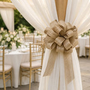 Gold burlap pull bow securing white sheer fabric on a post at an outdoor reception - thumbnail number 8
