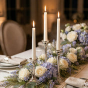 Three lit white taper candles in silver stands among purple and white flowers - thumbnail number 4