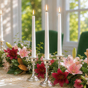 Three lit white taper candles in silver holders among pink and red lilies - thumbnail number 5