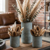 Dried pampas grass and botanical arrangements in three corrugated metal vases on a table - thumbnail number 6