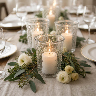 Lit white pillars in a Hobnail Candle Holder setup on a rustic table runner with white ranunculus - thumbnail number 4