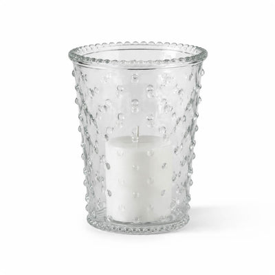 An unlit white pillar candle inside a clear glass Hobnail Candle Holder on a white studio backdrop - thumbnail number 2