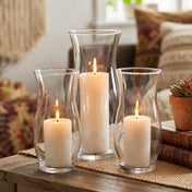 Three lit pillar candles in hurricane glass vases on a wooden table - thumbnail number 8