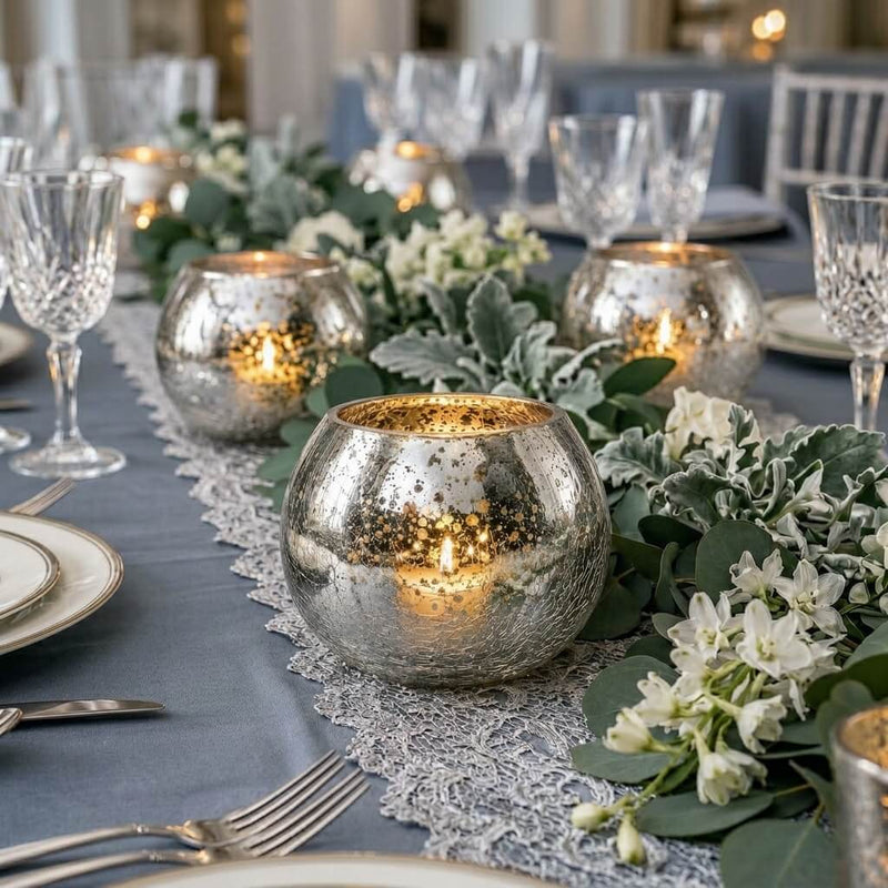 Glowing candles in a Mercury Glass Silver Ivy Bowl on a blue tablescape with greenery - thumbnail number 6