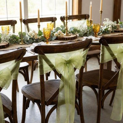 Wooden chairs with sage organza sashes at a decorated dining table - thumbnail number 6