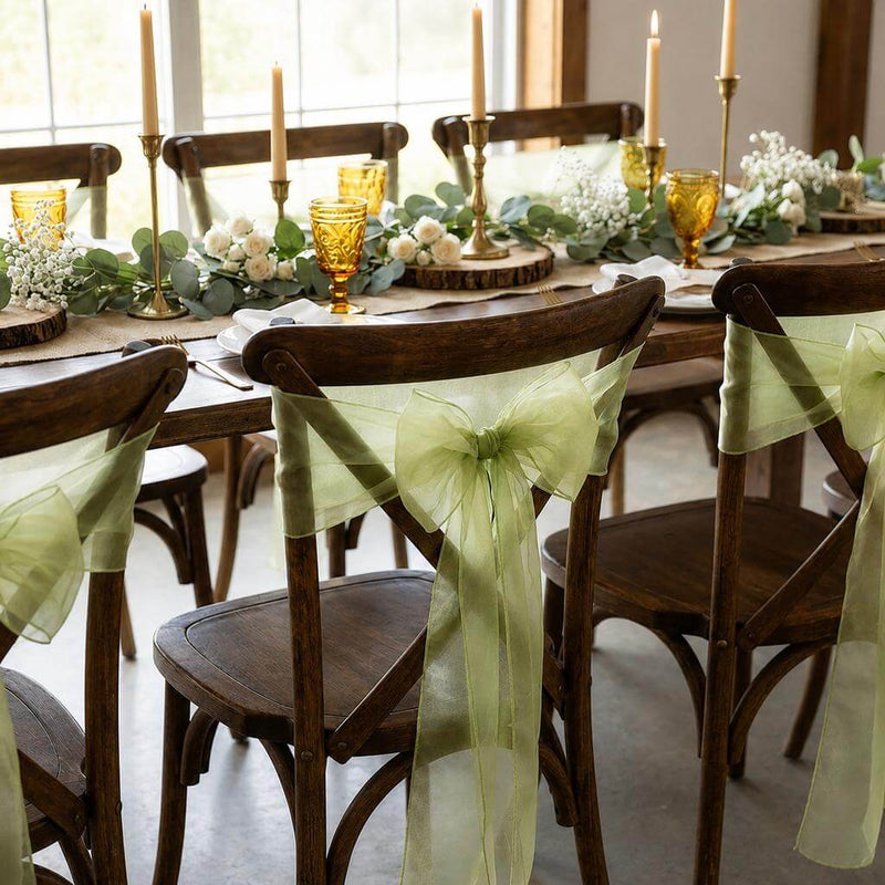 Wooden chairs with sage organza sashes at a decorated dining table - thumbnail number 6