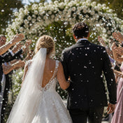 Bride and groom walk as guests toss white confetti - thumbnail number 3