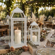 White contemporary metal lanterns with lit candles as centerpieces on an outdoor event table - thumbnail number 2