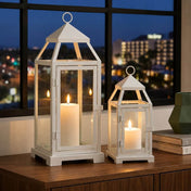 White contemporary metal lanterns with lit candles on a table by a window - thumbnail number 6