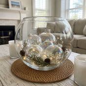 Iridescent glass ornaments styled in a large glass bowl with pinecones and starfish - thumbnail number 8