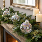 Iridescent glass ornaments styled in a pine garland on a mantelpiece - thumbnail number 7