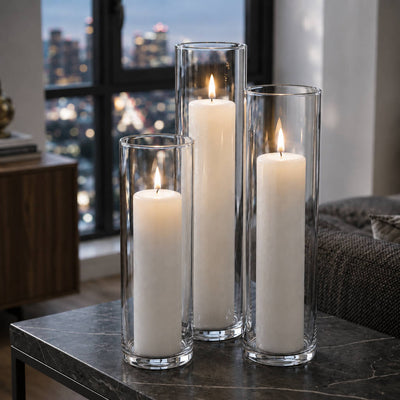 Three lit white pillar candles in glass cylinder vases on a marble table - thumbnail number 7