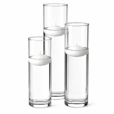 Three tall glass cylinder vases of varying heights filled with water and floating white candles - thumbnail number 4