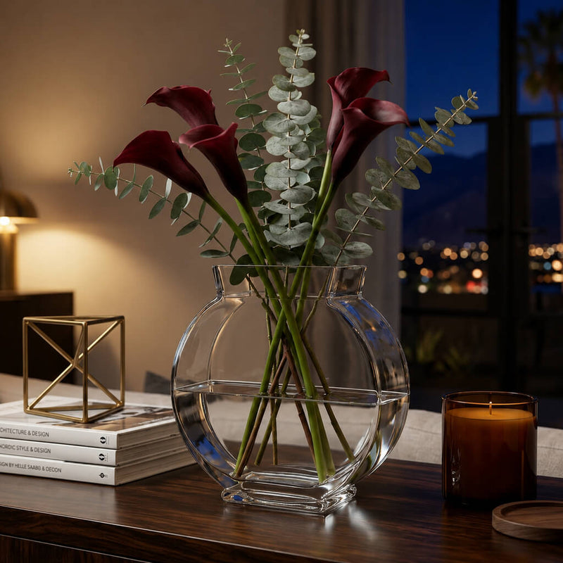 Clear circular vase with dark purple calla lilies and eucalyptus on a dark wooden table - thumbnail number 8