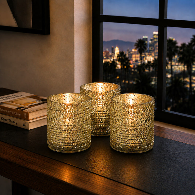 Pearly metallic gold mercury candle holders glowing on a table with city view background - thumbnail number 7