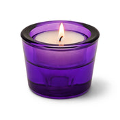 Lit tea light candle in a purple glass holder on a white background - thumbnail number 3