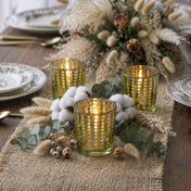 Three gold dotted glass candle holders with greenery and cotton on a burlap table runner - thumbnail number 4