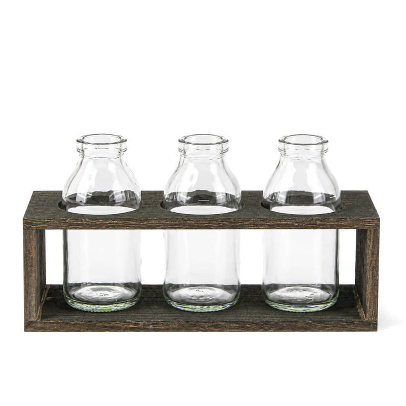 Three vintage milk bottle vases sitting in a rustic wooden stand - thumbnail number 1