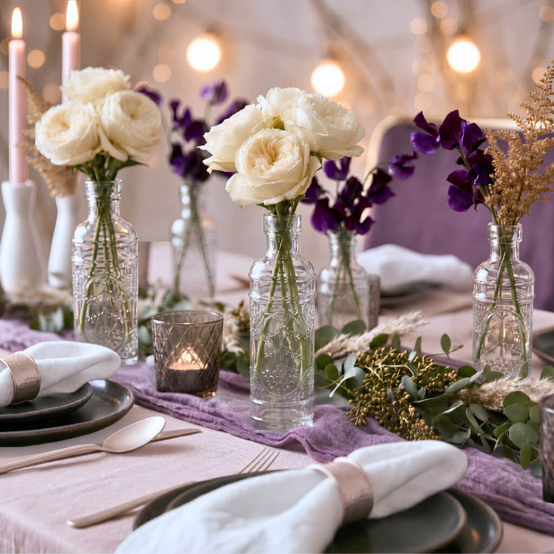 Bud vases featuring floral arrangements on a lavender runner and greenery - thumbnail number 4