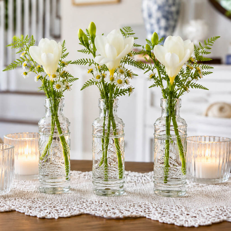 White flowers in Vintage Swirl Bud Vases with candles on a white lace runner - thumbnail number 6
