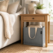 Gray canvas tote bag stored on the floor under a wooden side table in a living room - thumbnail number 8