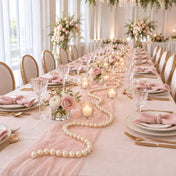 Long wedding dining table runner styled with a pink fabric drape, pearls, candles, and pink florals - thumbnail number 3