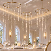 Hanging gold ring chandeliers adorned with dangling ivory faux pearl bead strands over a wedding table - thumbnail number 5