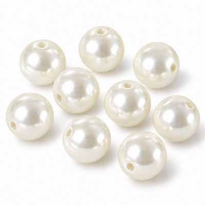Glossy ivory faux pearl craft beads with center holes scattered on a white surface - thumbnail number 1