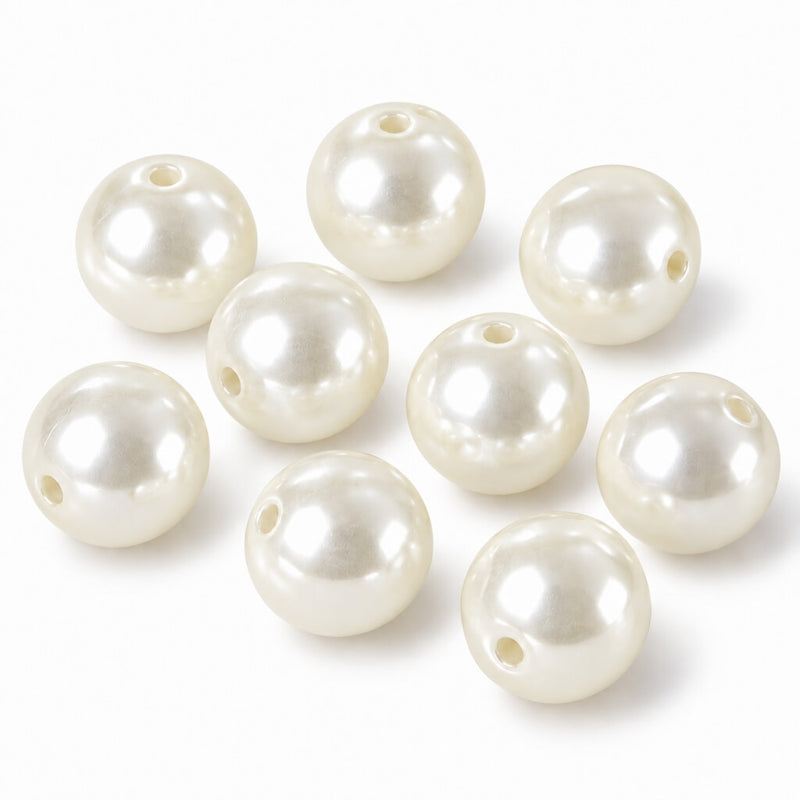 Glossy ivory faux pearl craft beads with center holes scattered on a white surface - thumbnail number 1