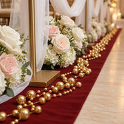 Gold faux pearl string beads draped along a red wedding aisle runner with floral decor - thumbnail number 5