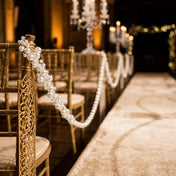 White faux pearl string beads draped along the backs of wedding chairs - thumbnail number 6