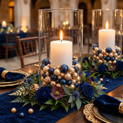 Navy blue and gold pearl beads fill glass vases around lit candles - thumbnail number 4