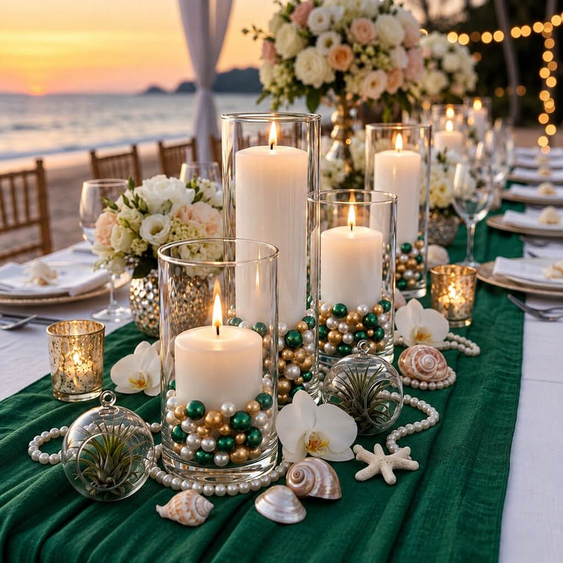Glass cylinder vases with lit candles, filled with green, gold, and white pearls on a coastal table - thumbnail number 3